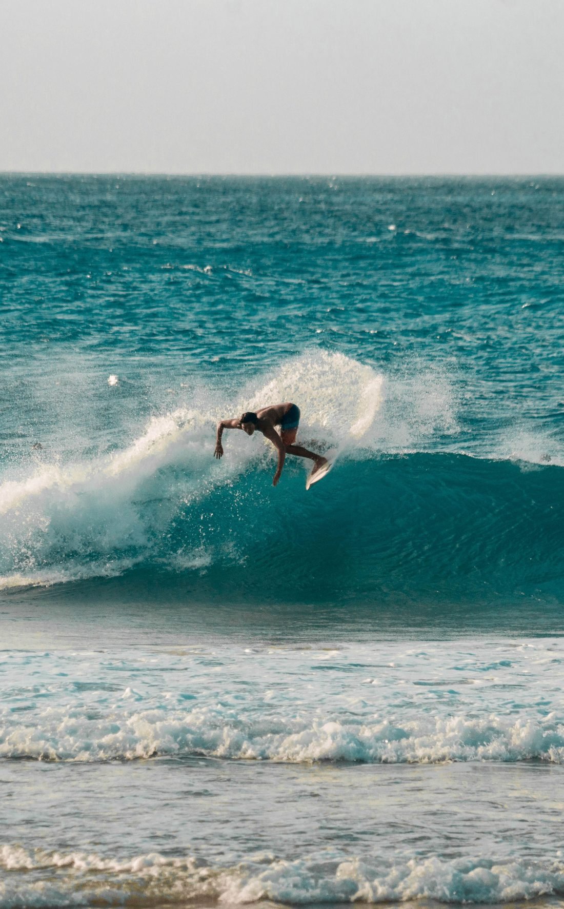 A surfer riding a wave on Bali's west coast